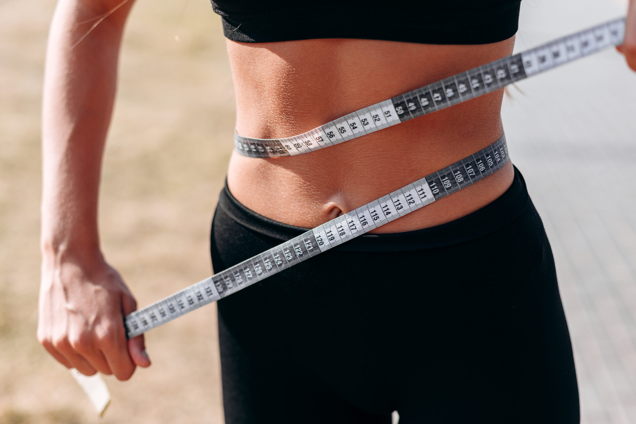 Closeup tape measure on a waist. - Concept diet and figure